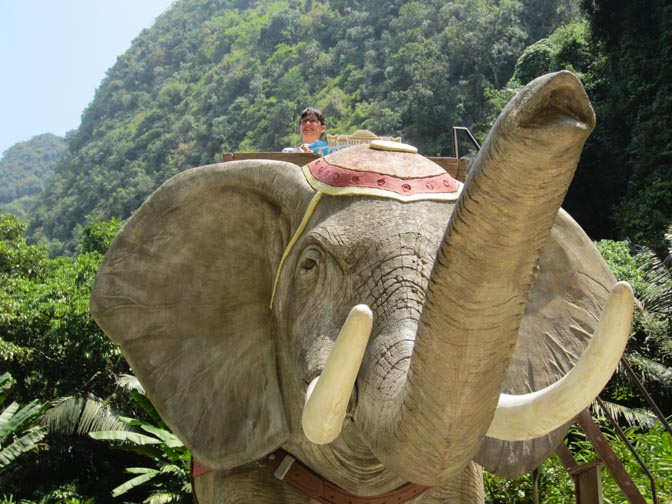 Sara sits on a fake elephant at the Lost World of Tambun in Malaysia